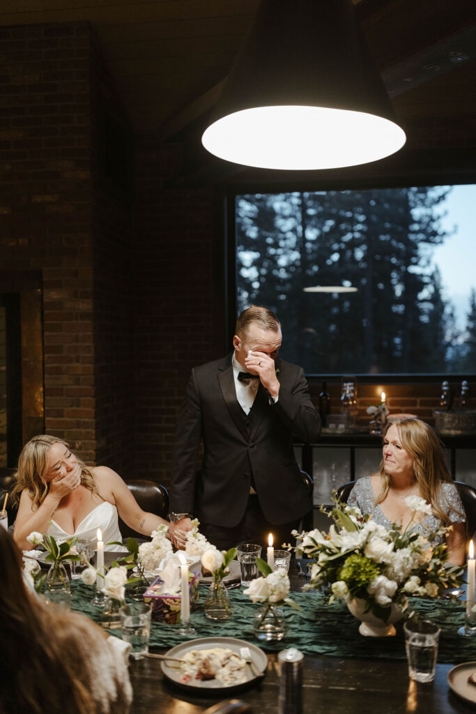 man wiping a tear with his wife covering her mouth during speeches at their donner lake elopement