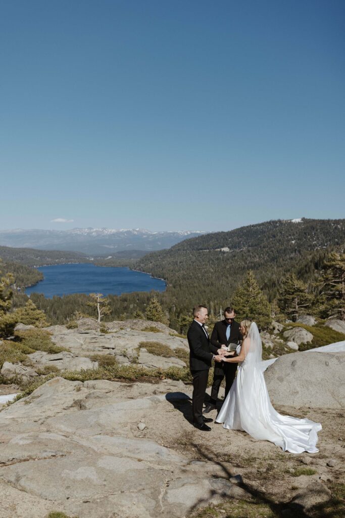 couple holding hands during elopement ceremony overlooking donner lake