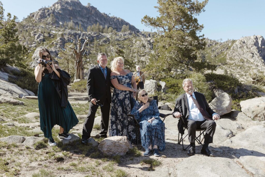 family members watching couple elope in donner lake with the mountains in the background