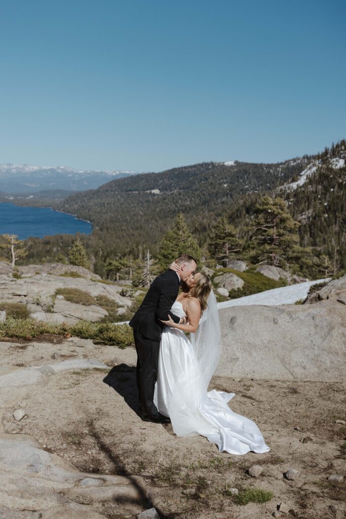 bride and groom share first kiss overlooking donner lake