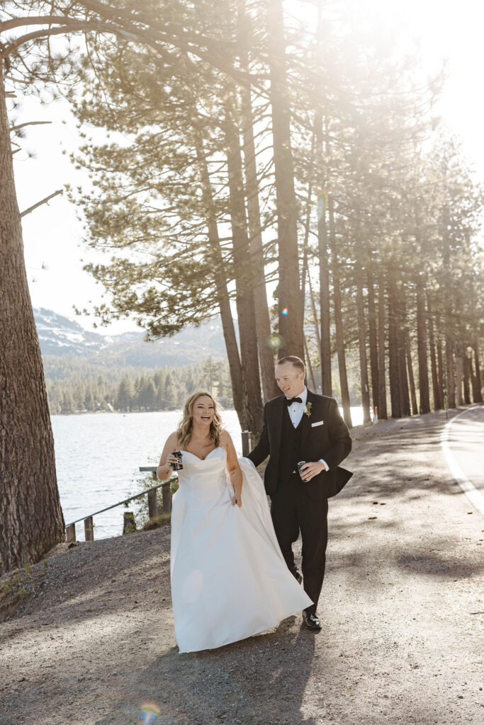 elopement couple walking and smiling holding beers walking next to donner lake 