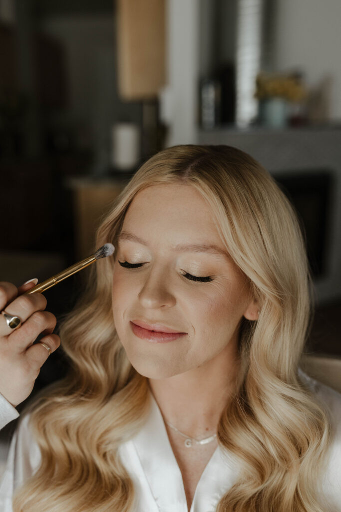 Bride with eyes closed as she gets her make up done