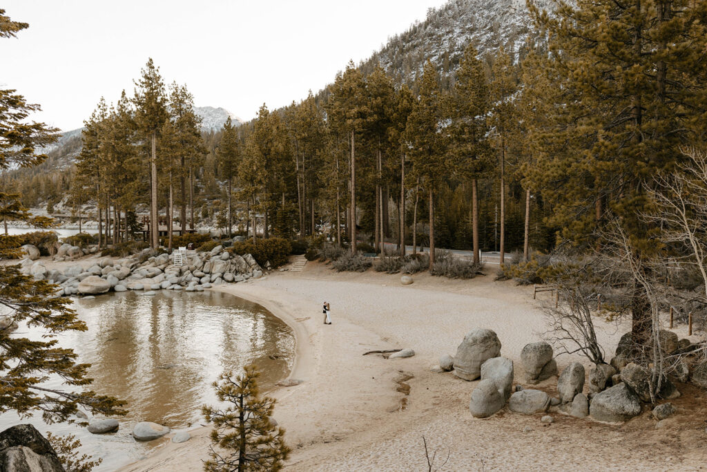 couple in lake tahoe at sand harbor on the beach in the distance