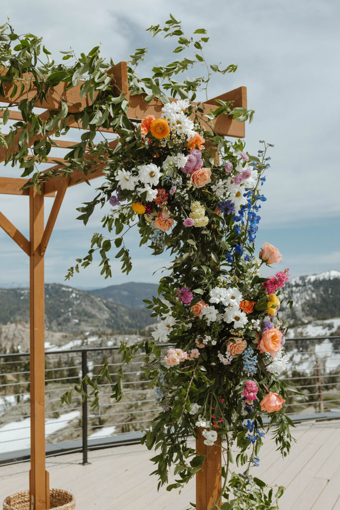 Colorful flowers decorating wooden arch at High Camp with mountains in background