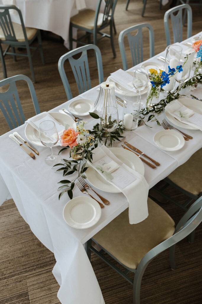 Wedding reception dinner table with copper silverware and colorful flower decor at Palisades Tahoe