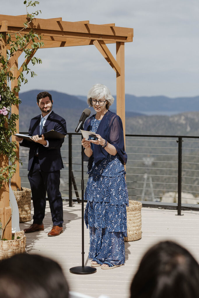 Wedding guest reading into microphone during ceremony at High Camp