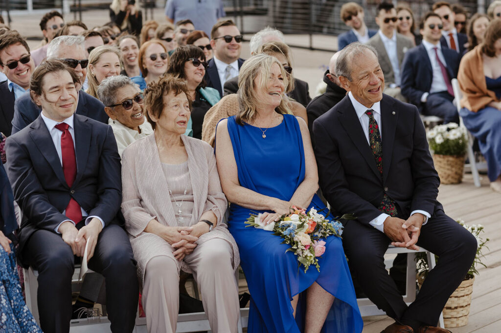 Groom's family smiling while watching wedding ceremony at High Camp