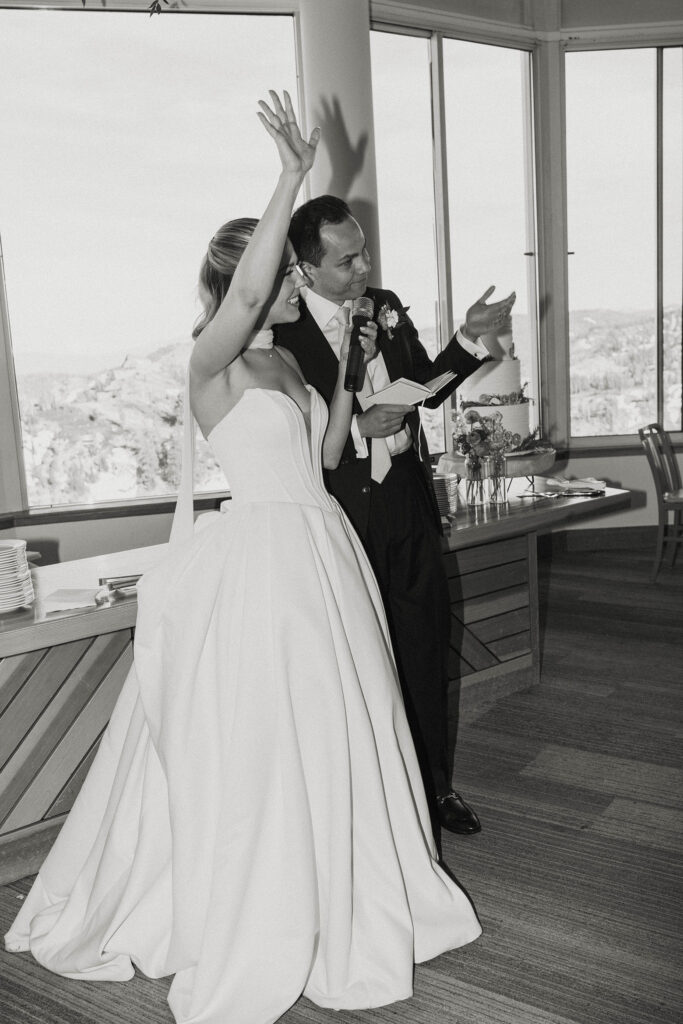 Wedding couple speaking during reception at Palisades Tahoe with mountains in background