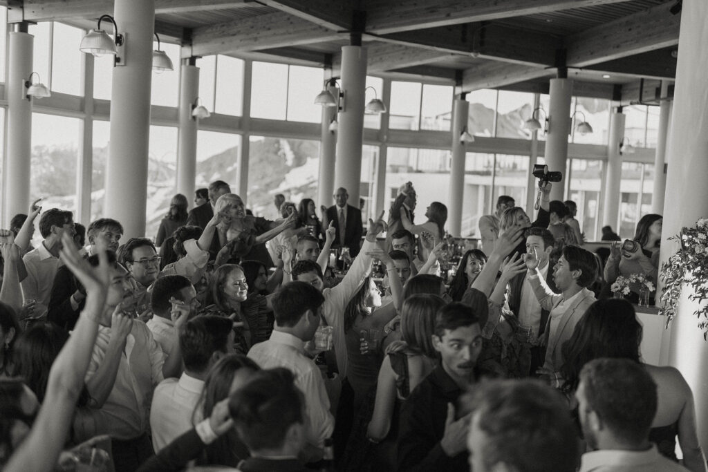 Wedding guests celebrating and dancing inside during reception at High Camp