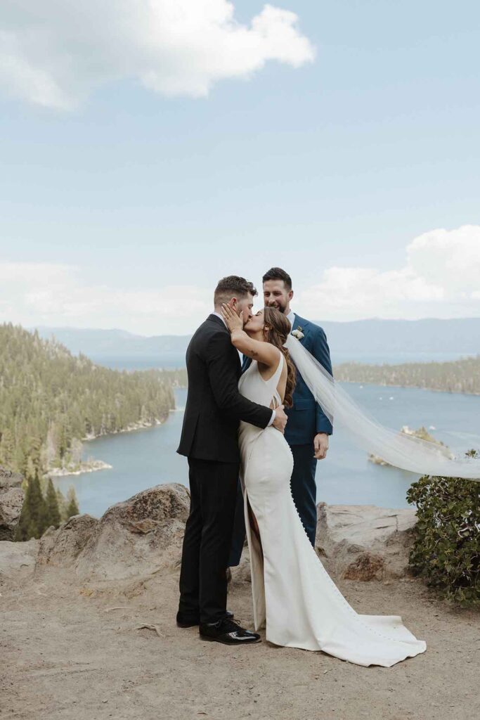 Elopement couple kissing after ceremony at Emerald Bay with Lake Tahoe and pine trees in background