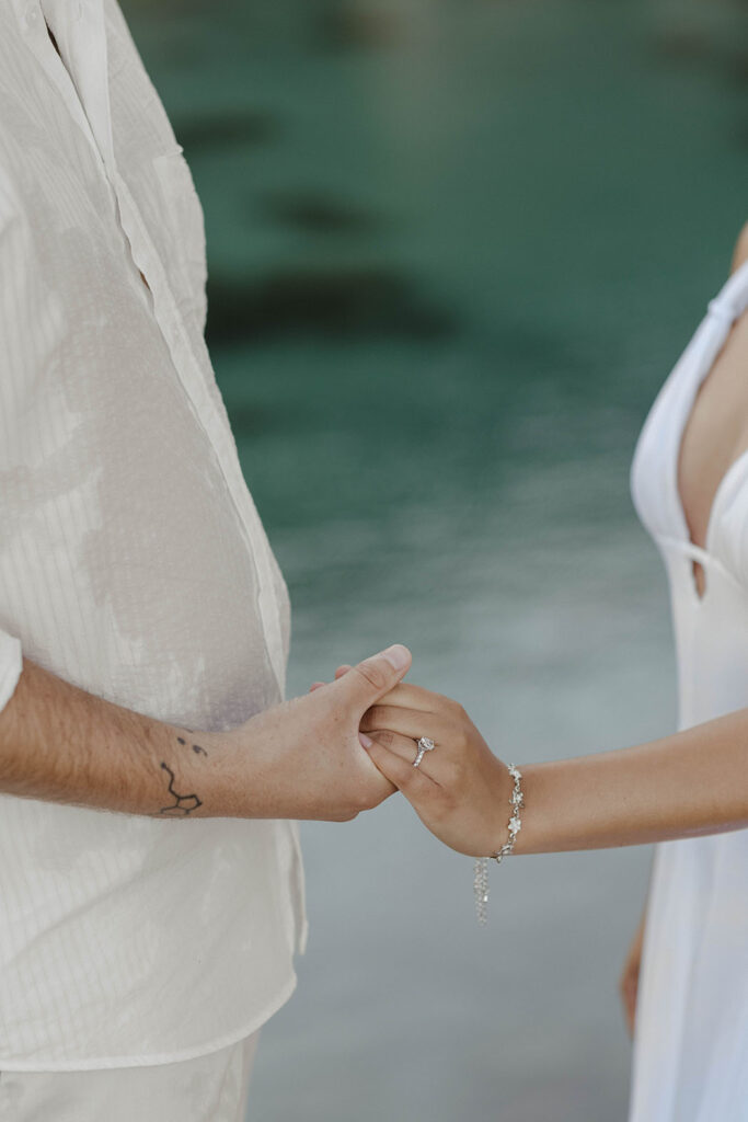 Close up of engagement couple holding hands with engagement ring on woman's finger