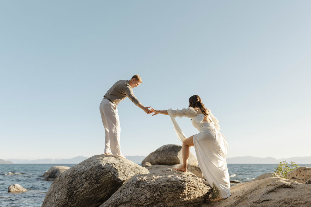 man helping woman up a rock in north lake tahoe