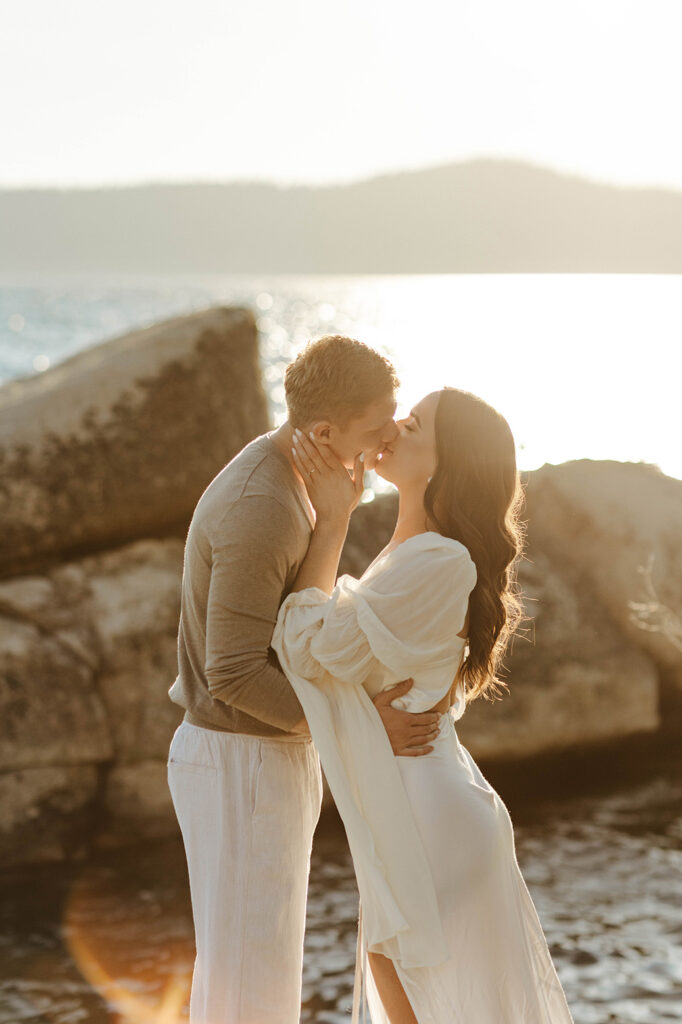 engagement couple kissing on some rocks at sunset in north lake tahoe