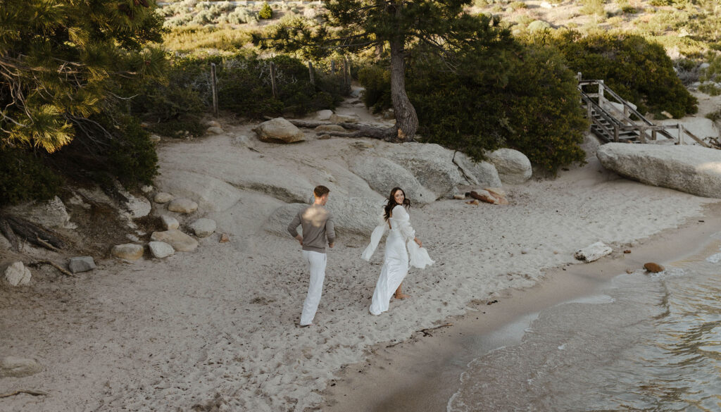 man chasing woman as she laughs on the beach in lake tahoe