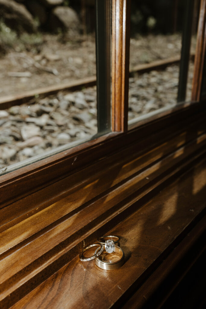 Wedding rings on wooden ledge next to window during South Lake Tahoe Elopement