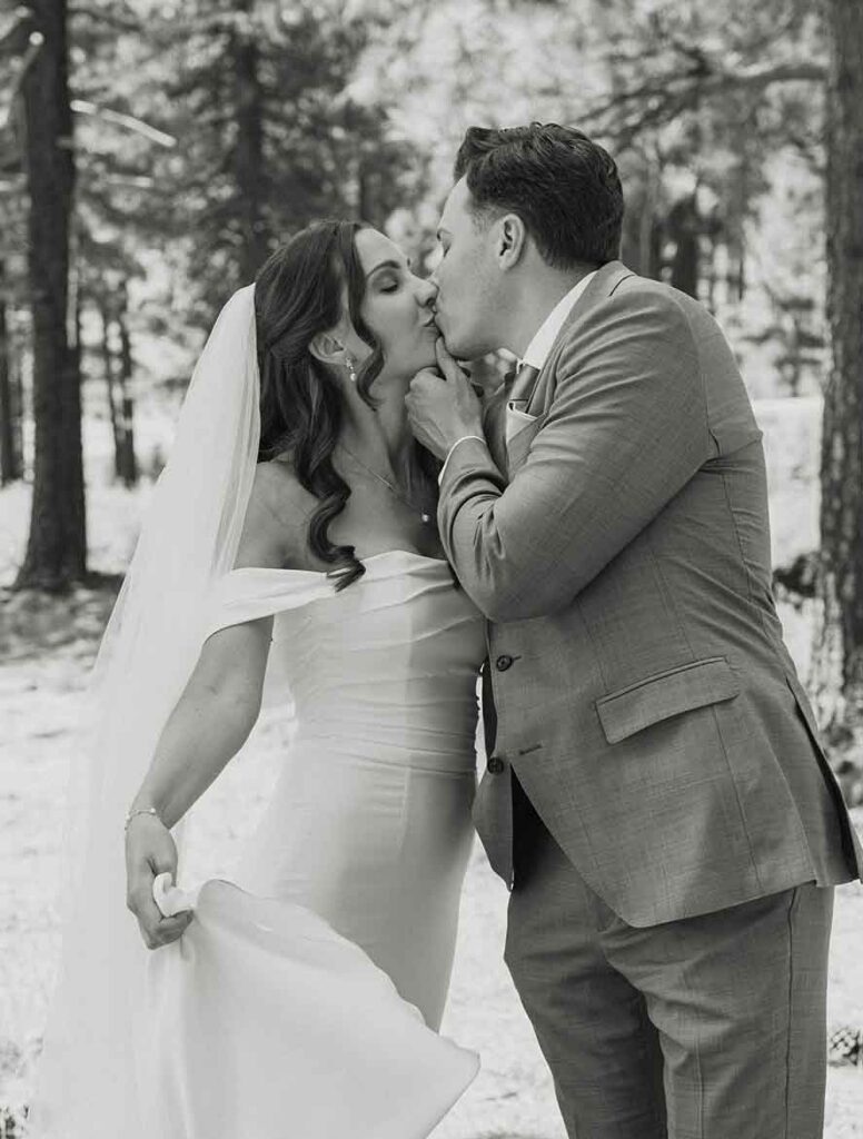 Elopement couple kissing after first look in South Lake Tahoe with pine trees in background