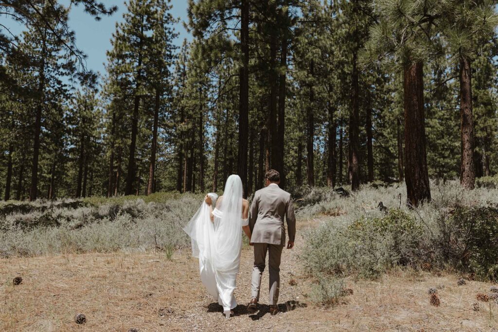 Elopement couple holding hands and walking along trail together in South Lake Tahoe