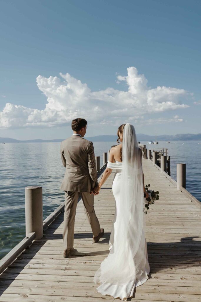 Elopement couple holding hands while walking out on pier together in South Lake Tahoe