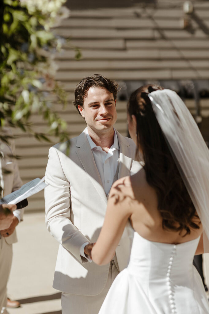 Groom smiling at bride while holding her hands during wedding ceremony at the Landing Tahoe Resort