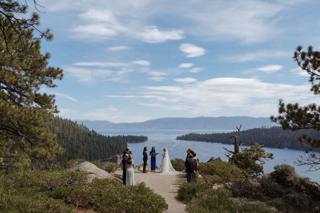 Overview of elopement ceremony at Emerald Bay with Lake Tahoe and mountains of pine trees in background