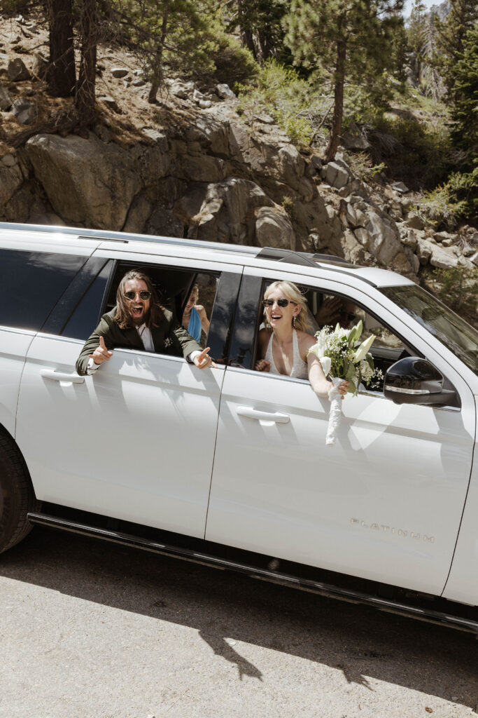 Elopement couple leaning out of car windows towards camera while smiling and celebrating in Lake Tahoe