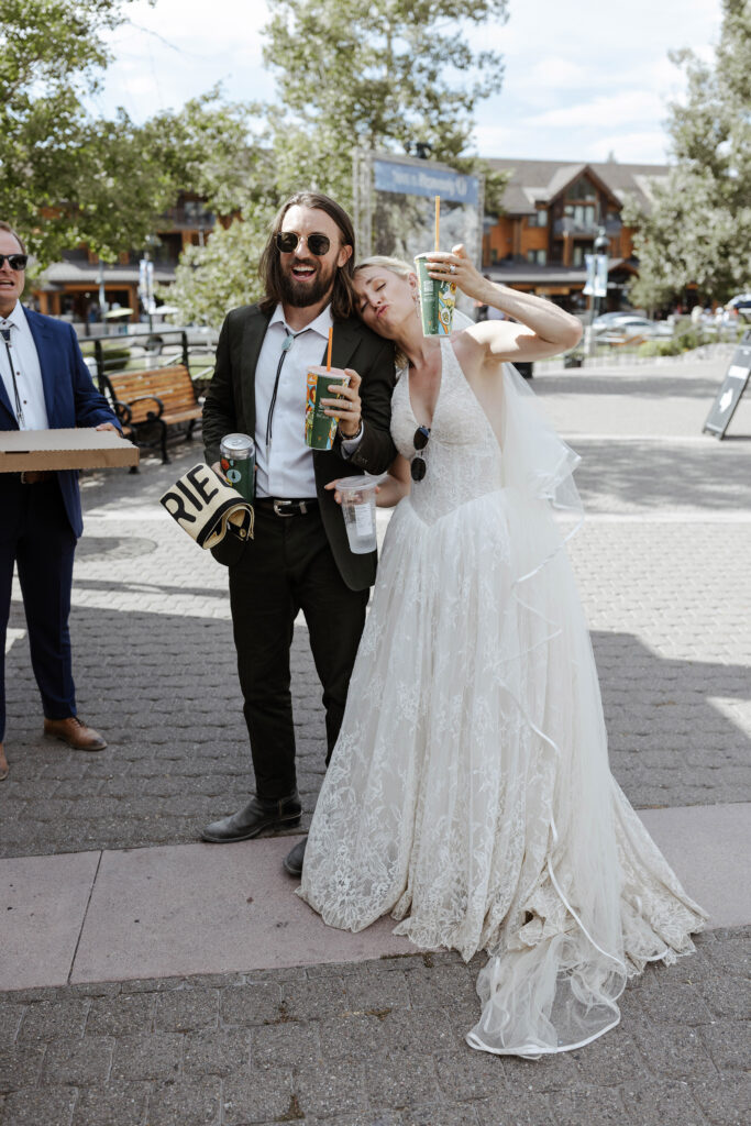 Elopement couple holding up drink cups together while smiling at Heavenly in Lake Tahoe
