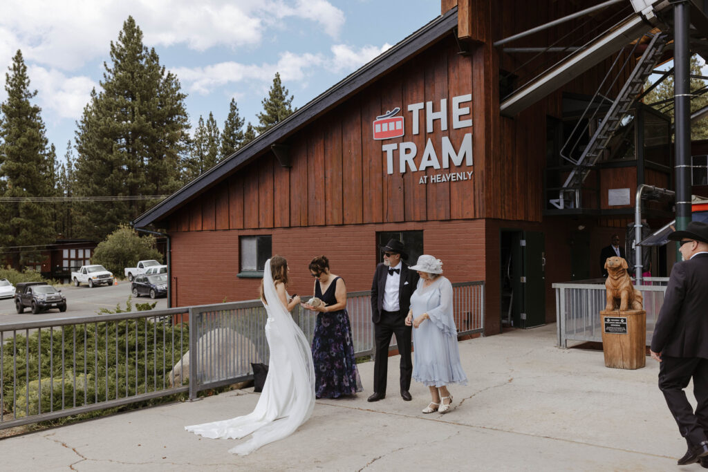 Wedding bride talking with family in front of cable car building at Heavenly Lake View Lodge