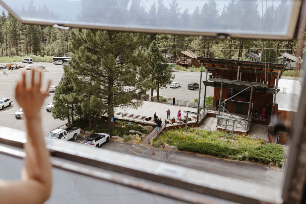 Wedding bride waving to family from window of cable car at Heavenly Lake View Lodge