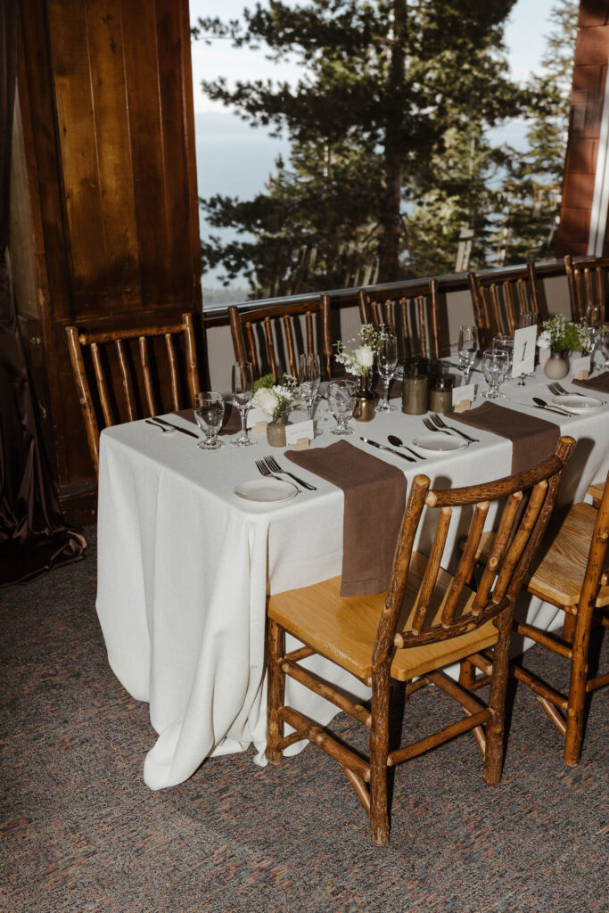 Wedding reception tables with wooden chairs and pine tree in background at Heavenly Lake View Lodge