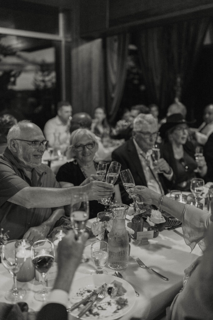 Wedding guests cheering champagne glasses during reception at Heavenly Lake View Lodge