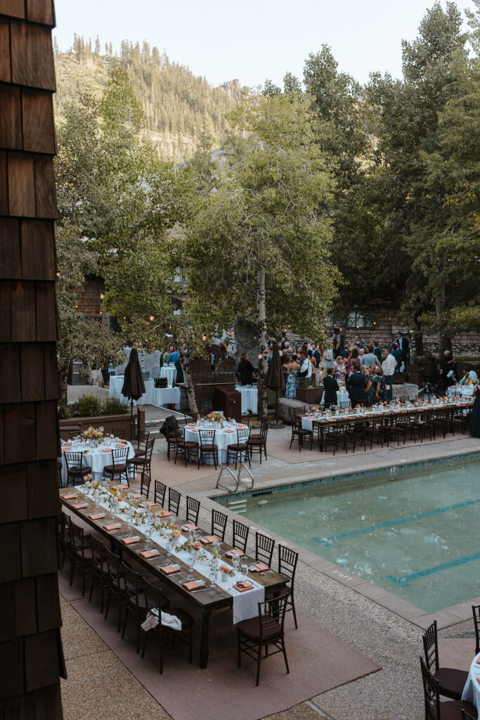 Wedding reception at the PlumpJack Inn with dark wooden tables surrounding pool and tall trees surrounding