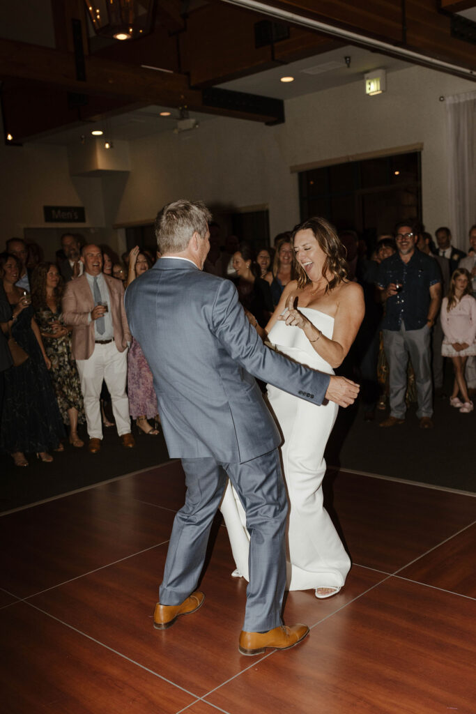 Wedding couple dancing together on dance floor while guests watch in background during reception at PlumpJack Inn
