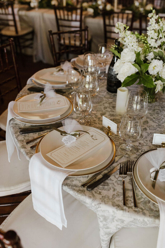 Close up of white plates and floral decor on wedding reception tables at Valhalla Tahoe