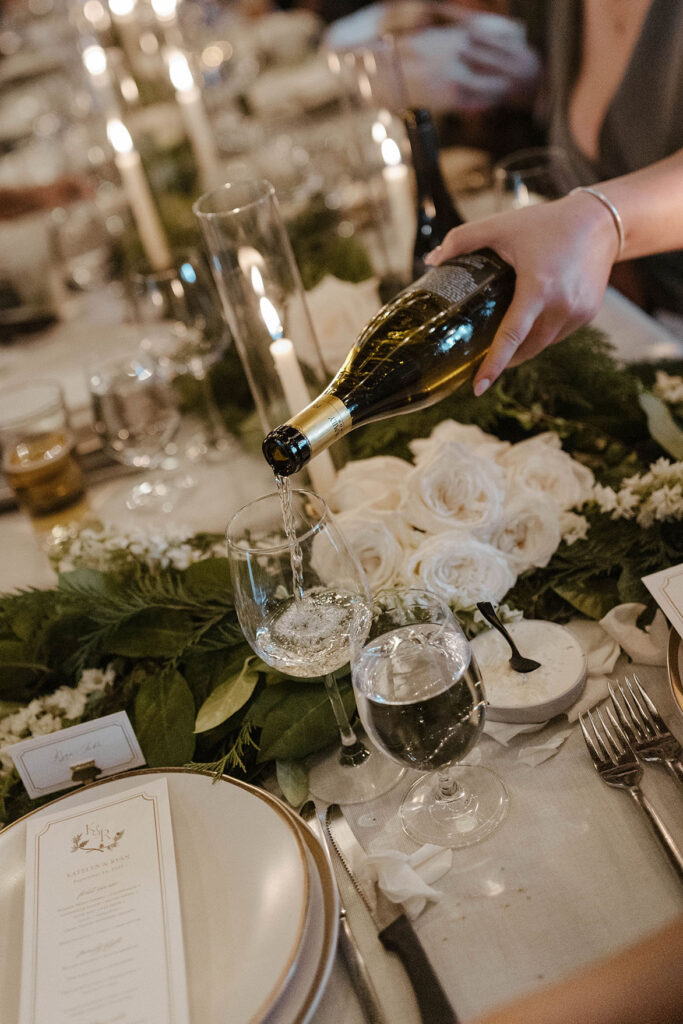 Close up of wedding guest pouring champagne into glass during reception at Valhalla Tahoe