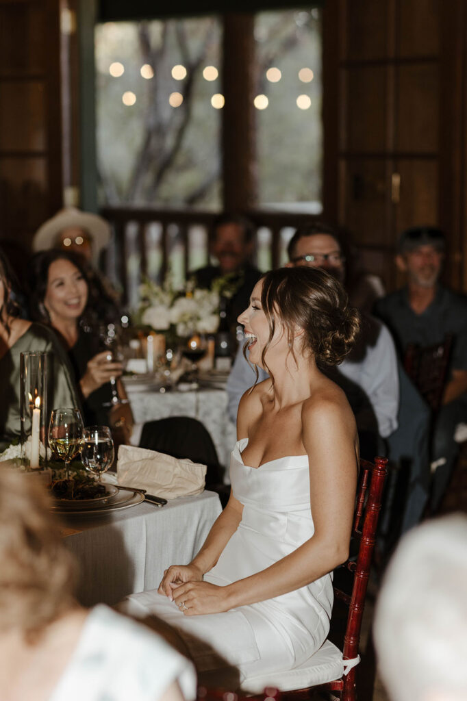 Bride laughing while sitting down at reception table at Valhalla Tahoe
