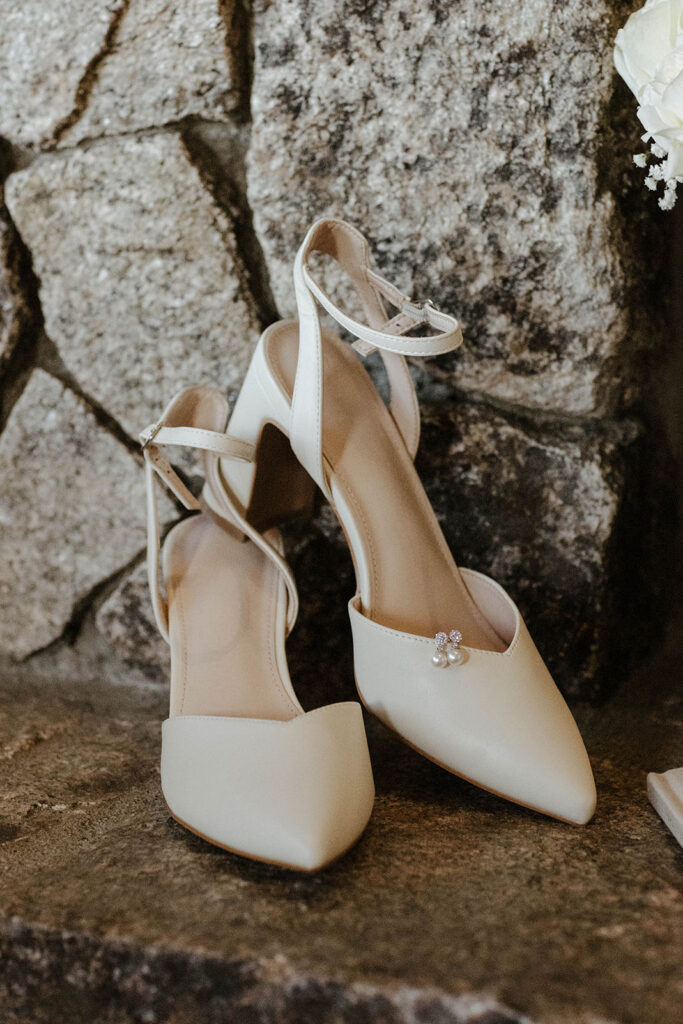 Elopement bride's shoes and earrings sitting on stone fireplace mantle in Lake Tahoe