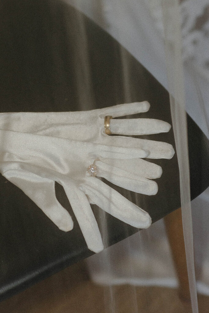 Close up of wedding rings on bride's gloves covered by veil at Garwoods Lake Tahoe