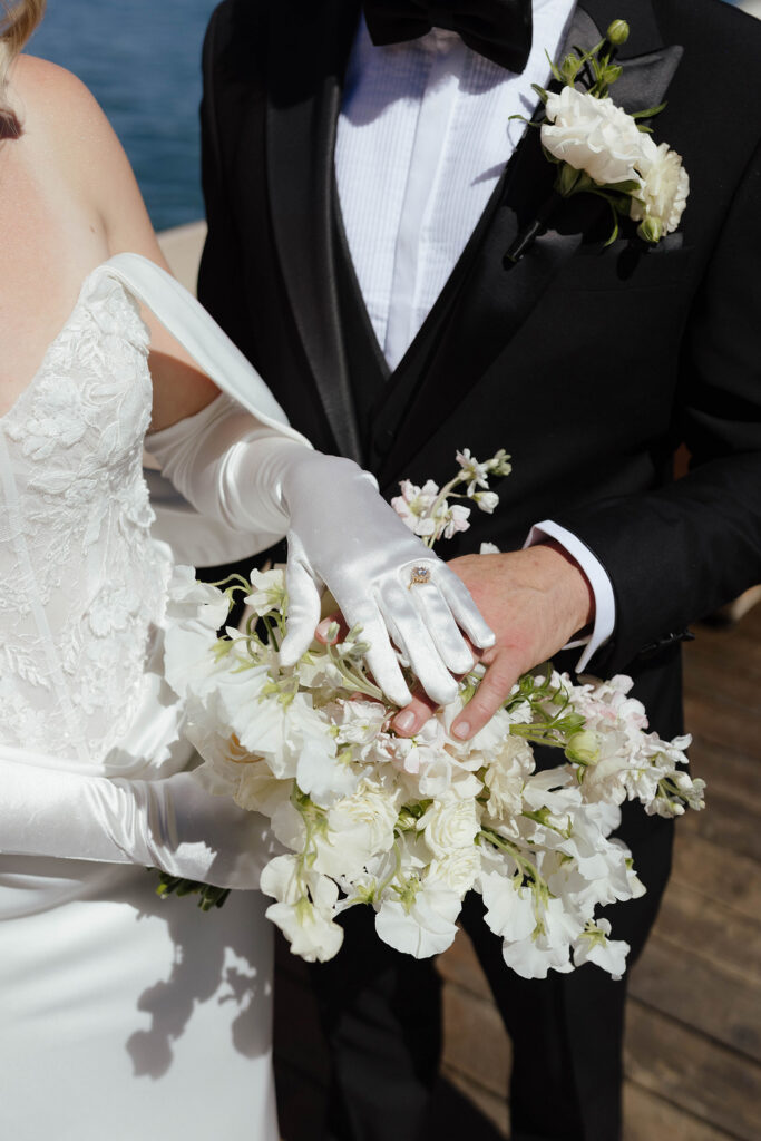 Close up of wedding couple's hands on top of floral bouquet at Garwoods at Lake Tahoe