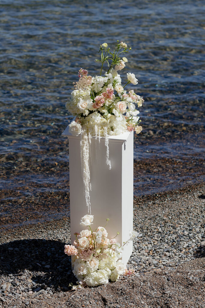 Colorful floral bouquet on top of white pillar on Lake Tahoe shoreline