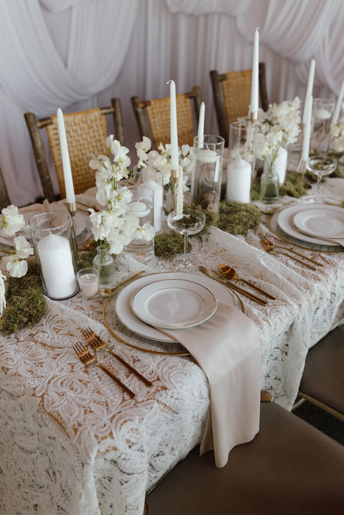 Wedding dinner table with white florals and golden cutlery on lace white tablecloth at Garwoods in Lake Tahoe