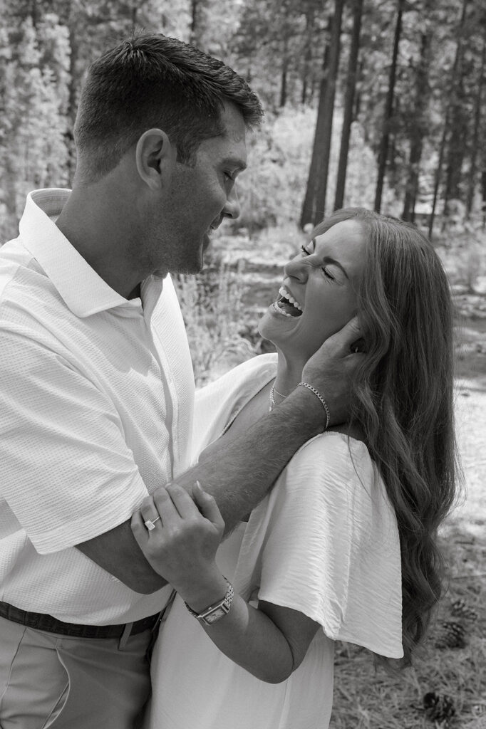 Man running fingers through fiancé's hair while she laughs and holds his arm at Sand Harbor
