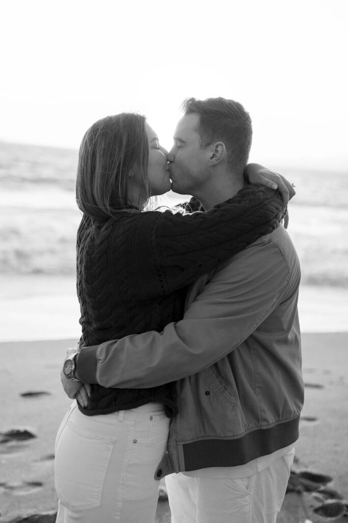 Black and white photo of a couple kissing on the beach in San Fransisco 