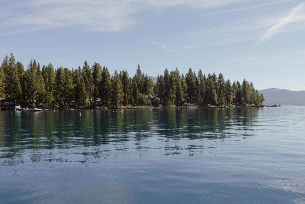 Lake Tahoe with houses in distance tucked around pine trees