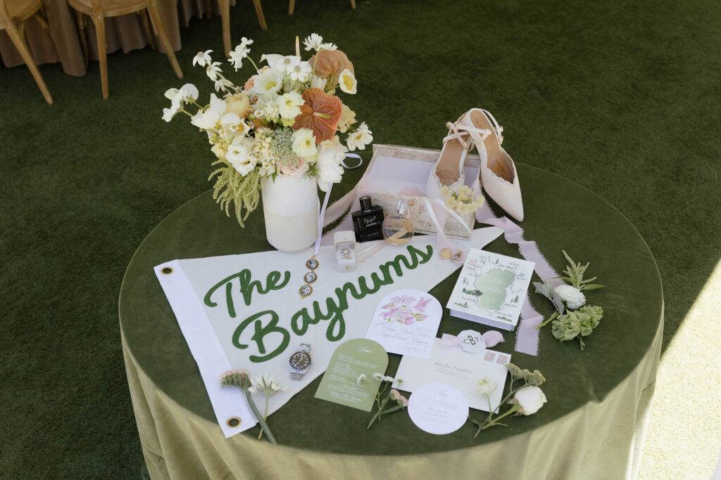 Wedding details in flatlay with green and white color scheme on table with green tablecloth at Everline Resort in Lake Tahoe