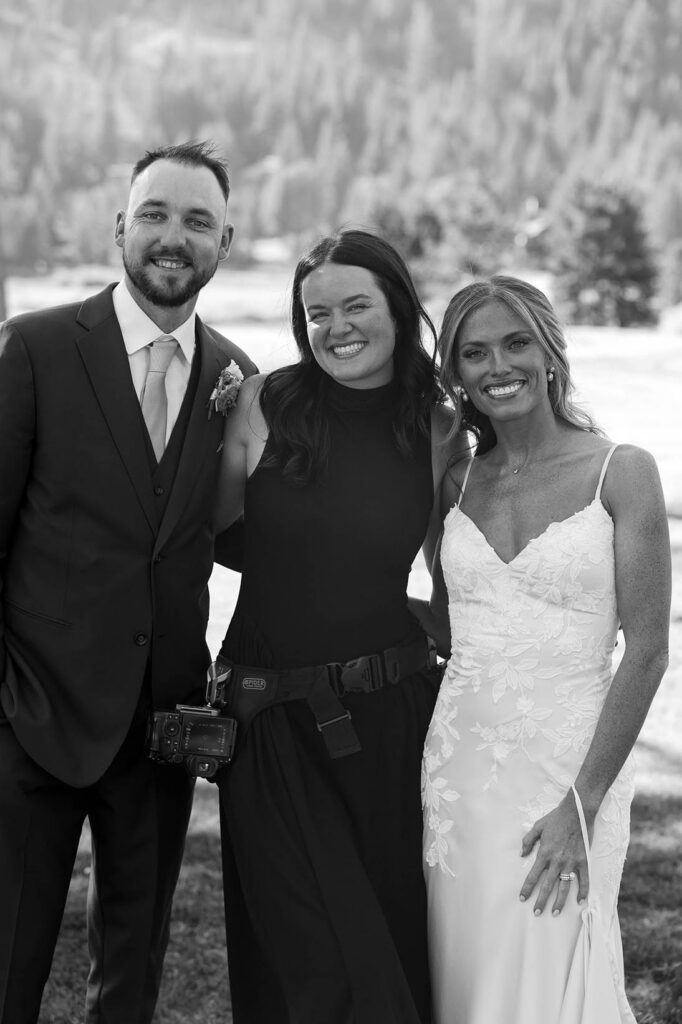 Wedding couple standing beside photographer Bridgette Wuest and smiling at camera at Everline Resort in Lake Tahoe