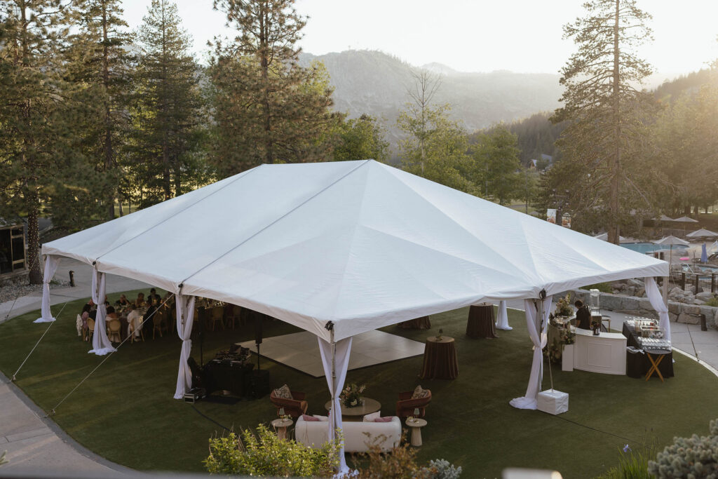 Wedding reception under large white gazebo at Everline Resort at Lake Tahoe with pine trees and mountains in background