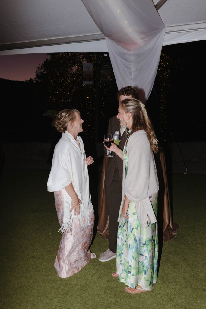 Wedding guests holding drinks and chatting during reception at Everline Resort in Lake Tahoe