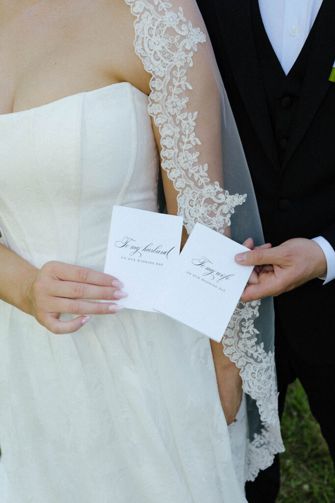 Close up of married couple each holding vow books at Kinship Ranch