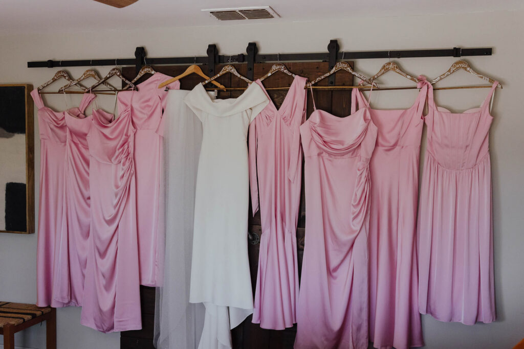 A white bridal gown surrounded by pink bridesmaid dresses at a South Lake Tahoe Airbnb