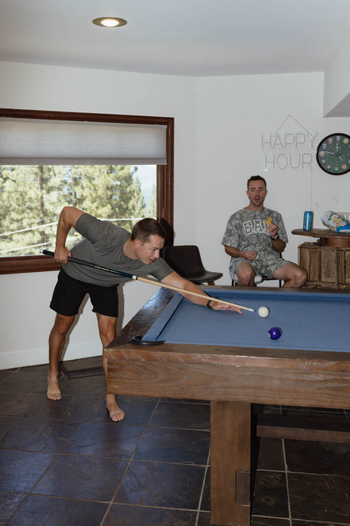 Groomsmen playing pool while getting ready at an Airbnb in South Lake Tahoe
